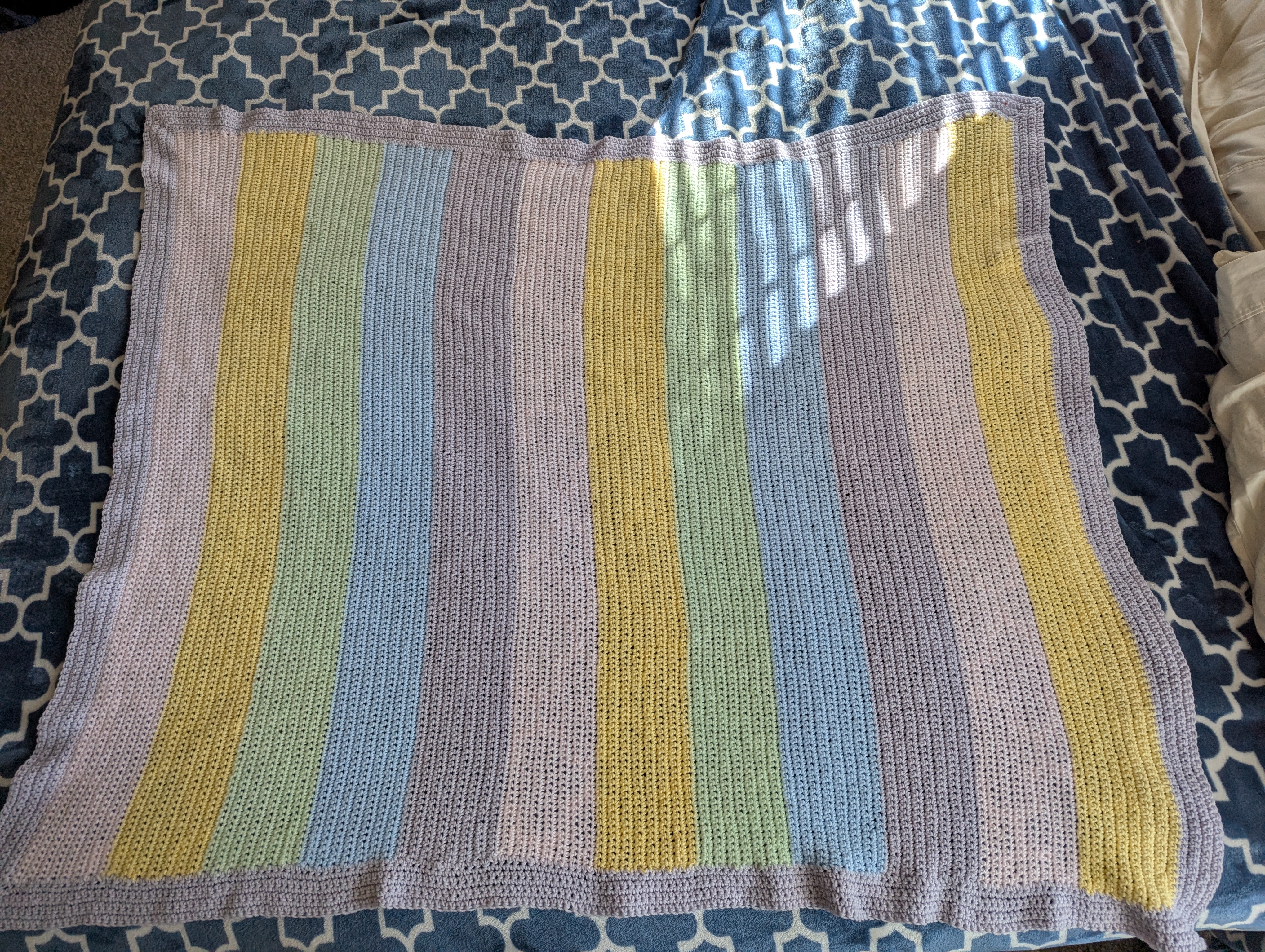 A multicolor, striped, pastel crocheted blanket